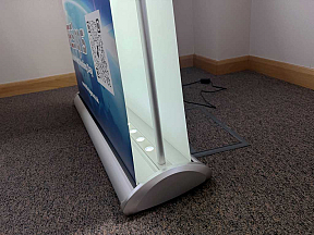 Double-sided LED illuminated banner stand with bright graphics for exhibitions, events and retail displays Double-sided LED illuminated banner stand with bright graphics for exhibitions, events and retail displays